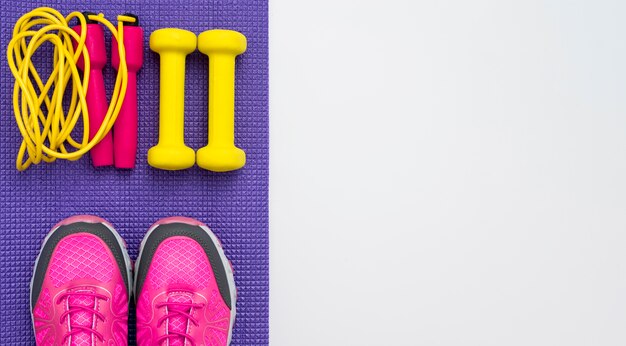 Top view of weights with jump rope and sneakers