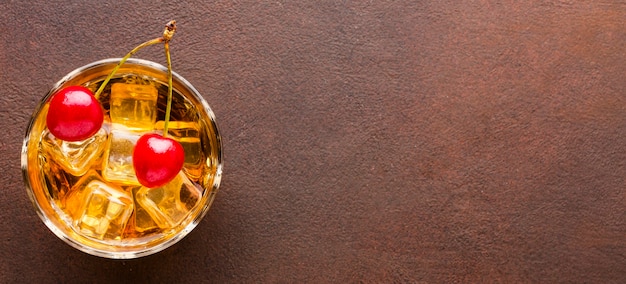 Foto gratuita bicchiere da whisky con vista dall'alto con ciliegie e copia-spazio