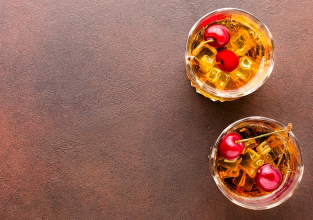 Top view whiskey on the rocks with cherries and copy-space