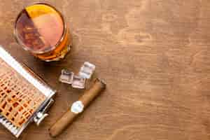 Foto gratuita whisky vista dall'alto con arancia e sigaro con spazio di copia