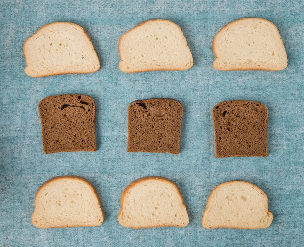 Vista dall'alto delle fette di pane bianco e nero su sfondo blu