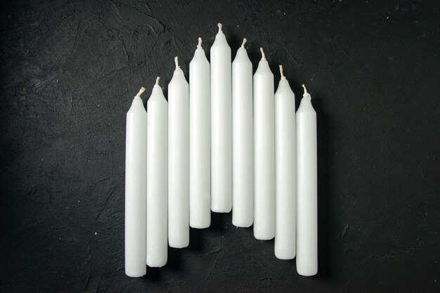 Top view of white candles on dark wall