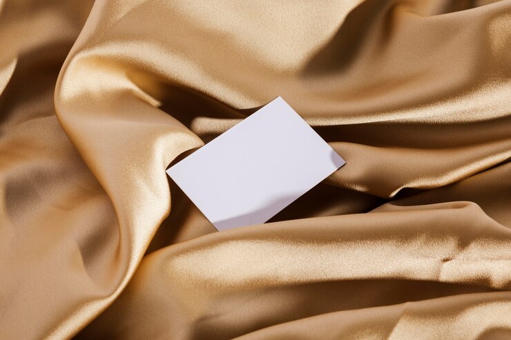 Free Photo top view white card on golden cloth