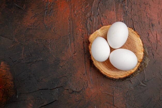 暗いテーブルの上の白い鶏の卵の上面図動物の食事食品着色料写真生の農場の空きスペース
