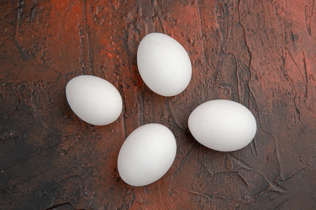 暗いテーブルの上の白い鶏の卵の上面図
