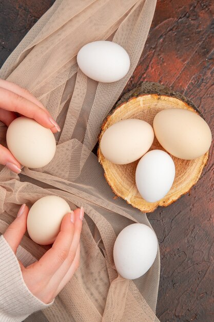 暗いテーブルの上の白い鶏の卵の上面図