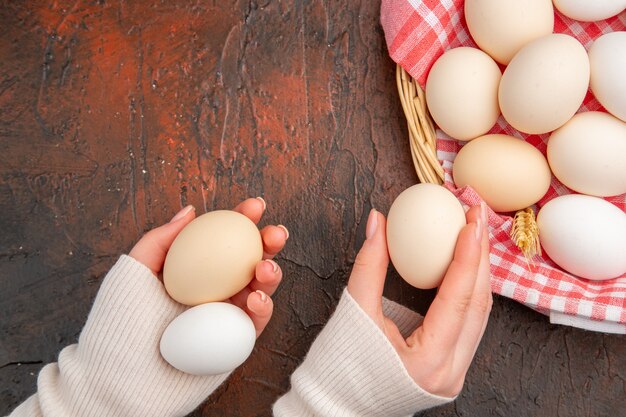 Top view white chicken eggs inside basket with towel on dark table food animal farm color photo meal raw