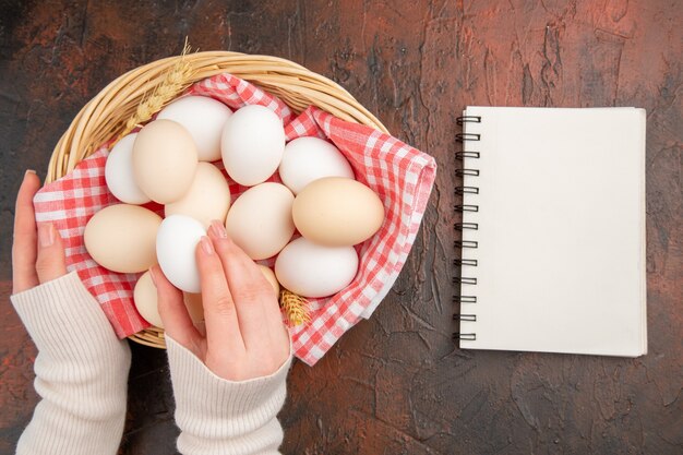 Top view white chicken eggs inside basket with towel on dark table food animal raw farm color photo meal