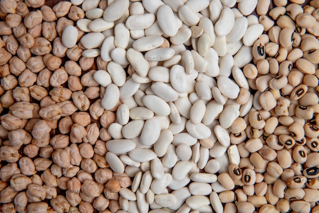 Top view white and colorful beans with peas on a brown wooden surface