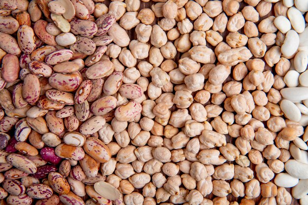 Top view white and colorful beans with peas on a brown wooden surface