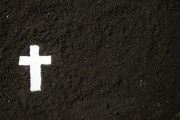 Top view of white cross shape with dark soil