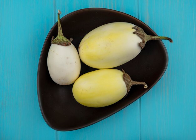 Top view white eggplant in bowl on turquoise background