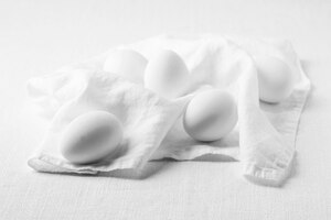 Вид сверху белые яйца и кухонное полотенце