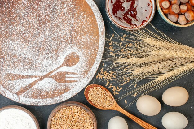 ダークケーキスウィートティービスケットシュガーペストリーパイに卵とフォークとスプーンの形の白い小麦粉の上面図