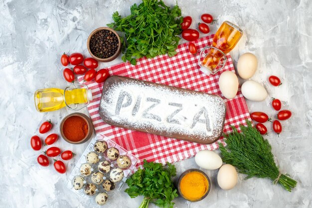 Top view white flour making pizza writing with different ingredients on white background egg flour milk pie dough