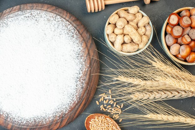 Top view white flour with fresh nuts on dark cookie sweet pie sugar cake tea pastry dessert biscuit