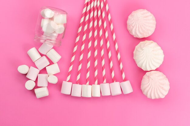 A top view white marshmallows with meringues on pink desk, sugar sweet color