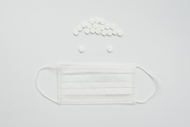 Free photo top view white mask and pills