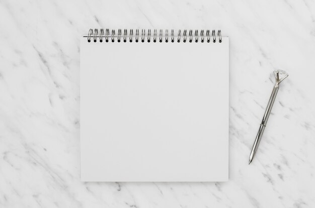 Top view of white notebook on marble desk