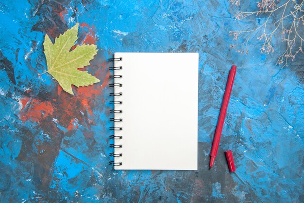 Вид сверху белый блокнот и ручка с листьями