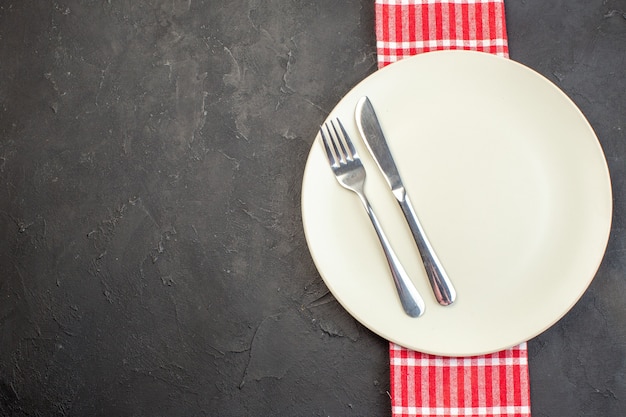 Free photo top view white plate with fork and knife on dark surface