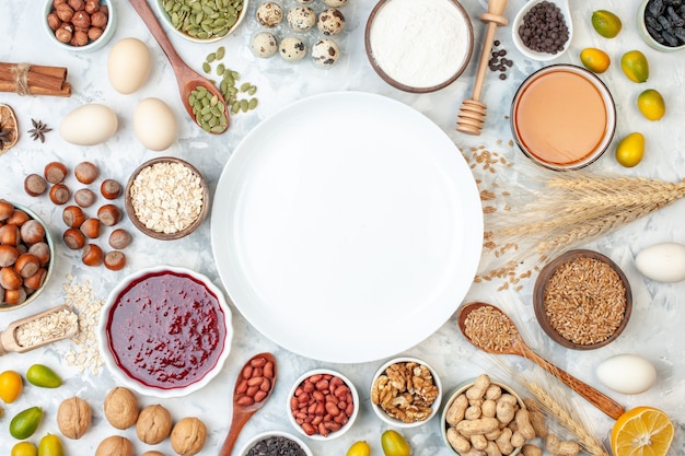 Foto gratuita vista dall'alto piatto bianco con uova di gelatina noci e semi diversi su pasta bianca zucchero colore torta biscotto dolce foto di noci