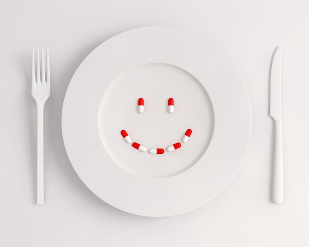 Вид сверху белая тарелка с таблетками, образующими улыбку, вилку и нож
