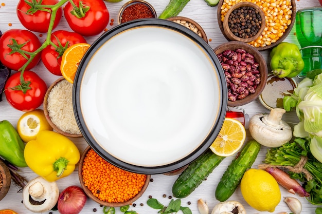 Top view of a white pot on collection of fresh vegetables for vegetarian dinner cooking