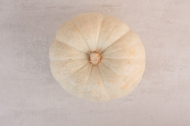 Top view of white pumpkin on white surface.