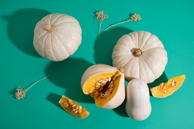 Top view white pumpkins on green background