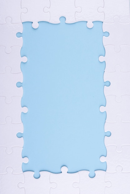 Вид сверху белые кусочки головоломки и синий фон