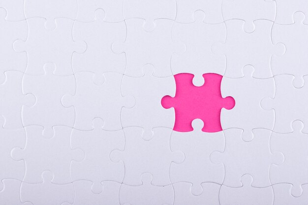 Top view white puzzle pieces and pink background