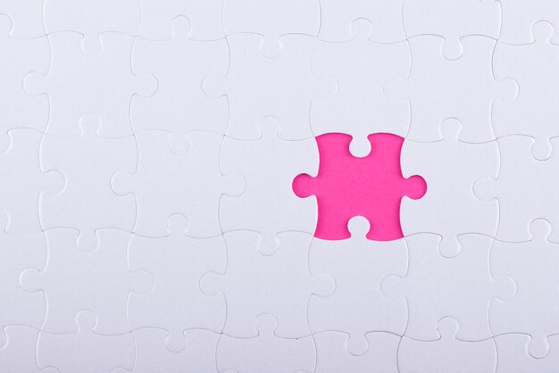 上面図の白いパズルのピースとピンクの背景