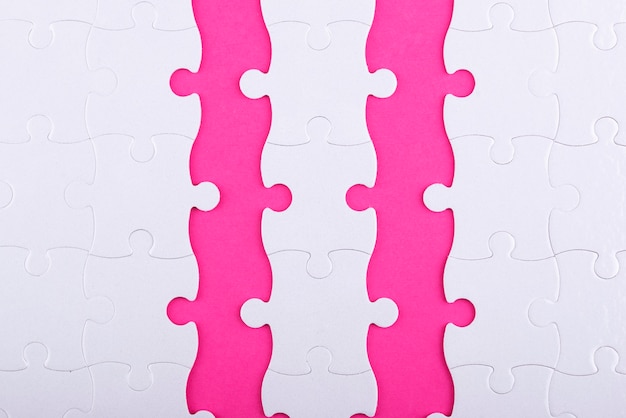 Free photo top view white puzzle pieces and pink background