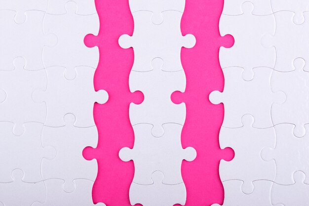 top view white puzzle pieces and pink background