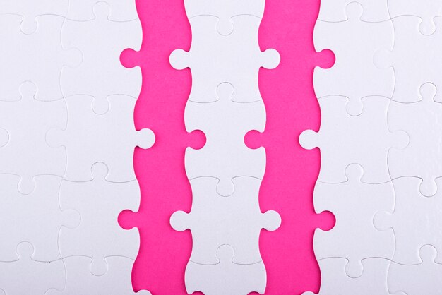 Top view white puzzle pieces and pink background