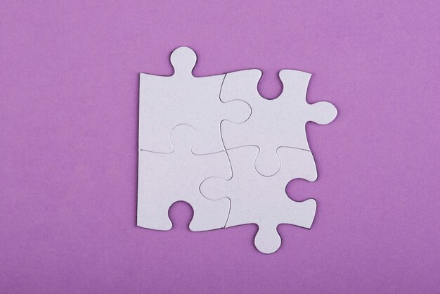 Top view white puzzle pieces and purple background