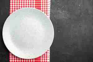 無料写真 コピー場所と暗いテーブルの上の赤と白の市松模様のナプキンの上面図白い丸いプレート