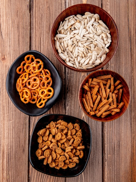 Top view white seeds in bowls with bagels and breadcrumbs on a wooden background