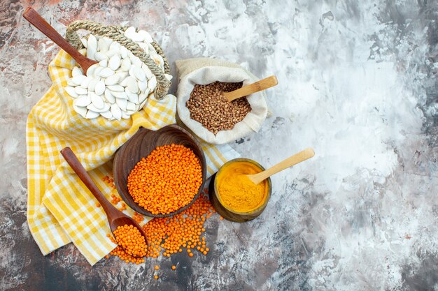 Top view white seeds with orange lentils and pepper on light surface