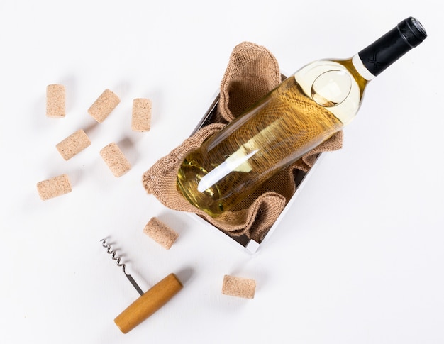 Top view white wine in bottle in wooden crate and linen bag on white  horizontal