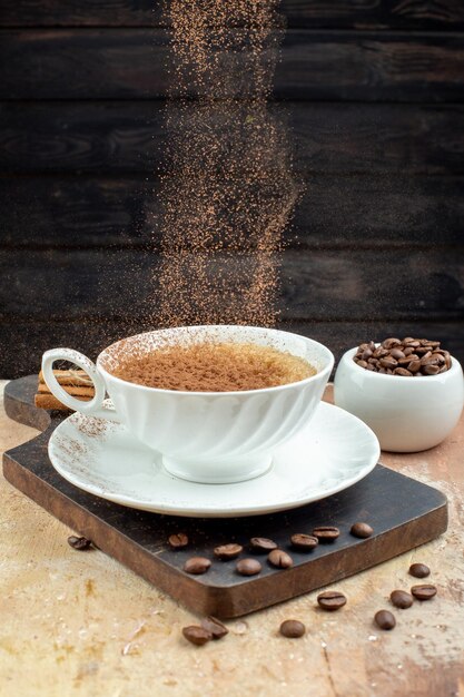 Top view of whole beans and hand holding delicious coffee on cutting board on mixed color background