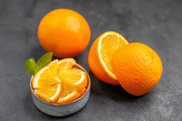 Top view of whole and chopped fresh lemons on dark background