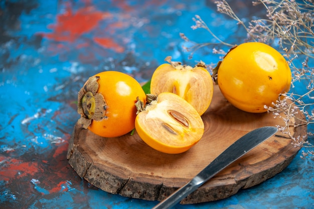 Top view of whole and cut diospyros kaki with knife