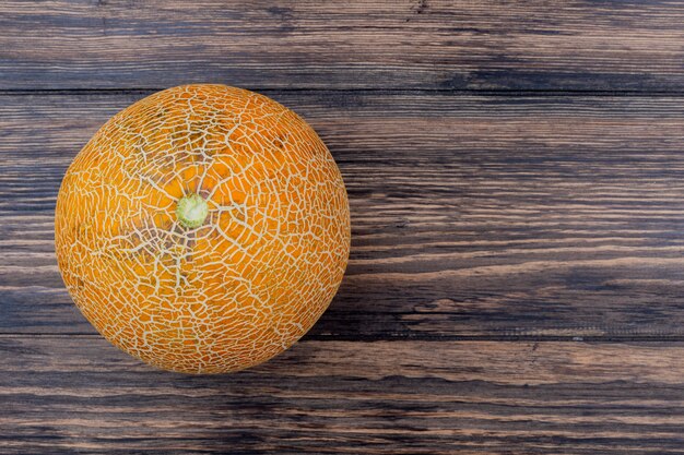 Top view of whole melon on wooden background with copy space
