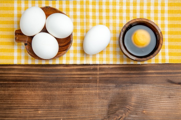 茶色の木製テーブル食品朝食木製卵の上面図全生卵