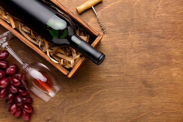 Top view wine bottle and glass with grapes and copy-space