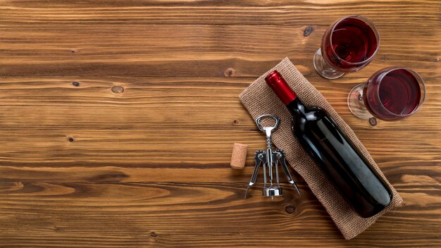 Top view wine bottle with glass on wooden background