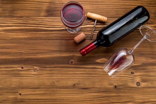 Top view wine bottle with glass on wooden background