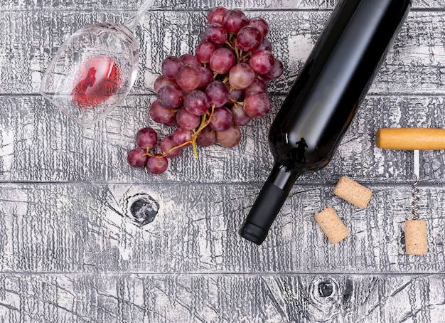 白い木製の水平のブドウの上から見るワインボトル